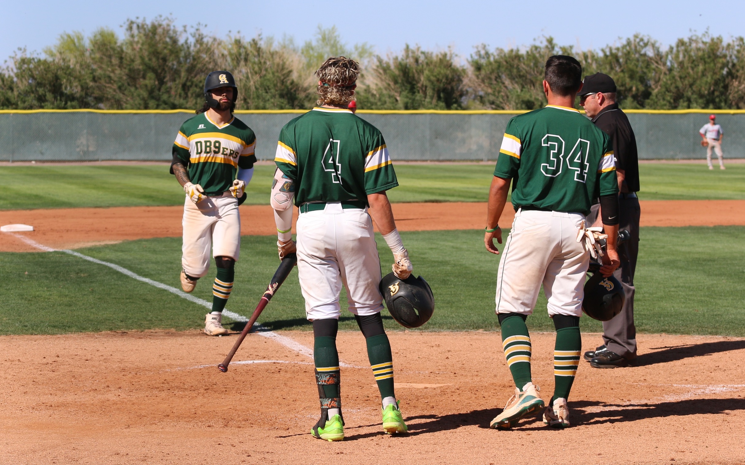 This one went WAY out over the right field fence. Dusty Garcia trots home as Chase Valentine (l) and Blake Avila (r) await the high helmet in Friday's win over Mesa.